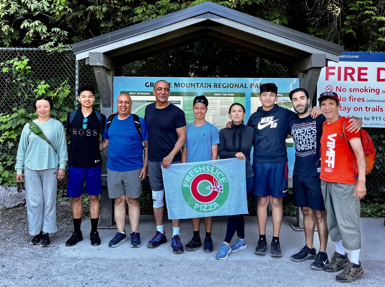 Freshslice Pizza HQ holding Freshslice Pizza banner at base of Grouse Mountain in Vancouver